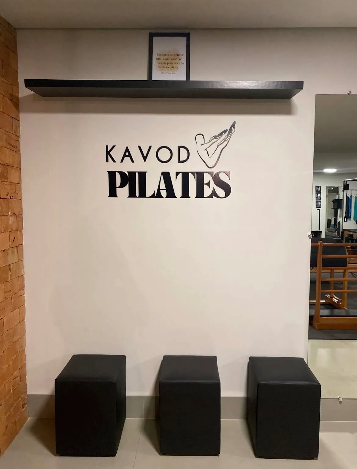 Recepção do estúdio com o logo Kavod Pilates na parede